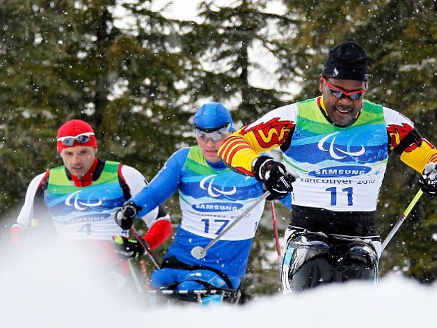 Fotografía de tres esquiadores de esquí fondo en silla