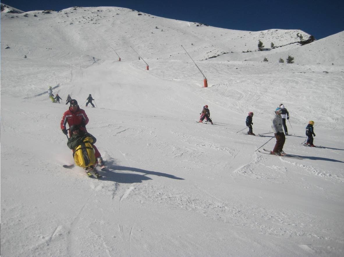 Fotografía de monitor esquiando con dual esquí en pista